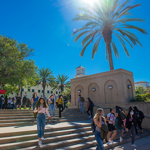 Students walking on campus near library.