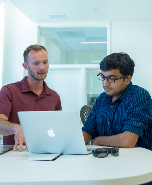 Faculty mentoring student outside in classroom.