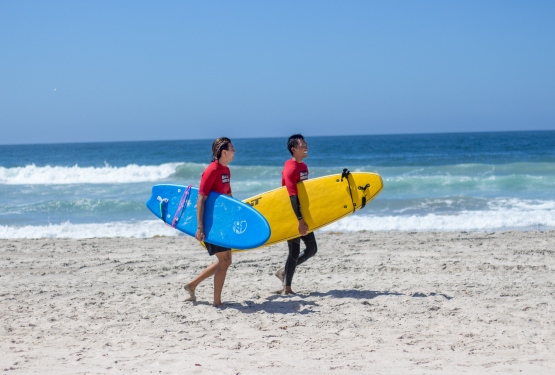 Student's walking along beach after surf class.