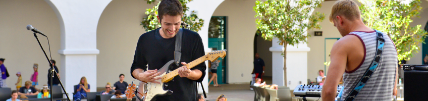 Students playing guitar in the student union.